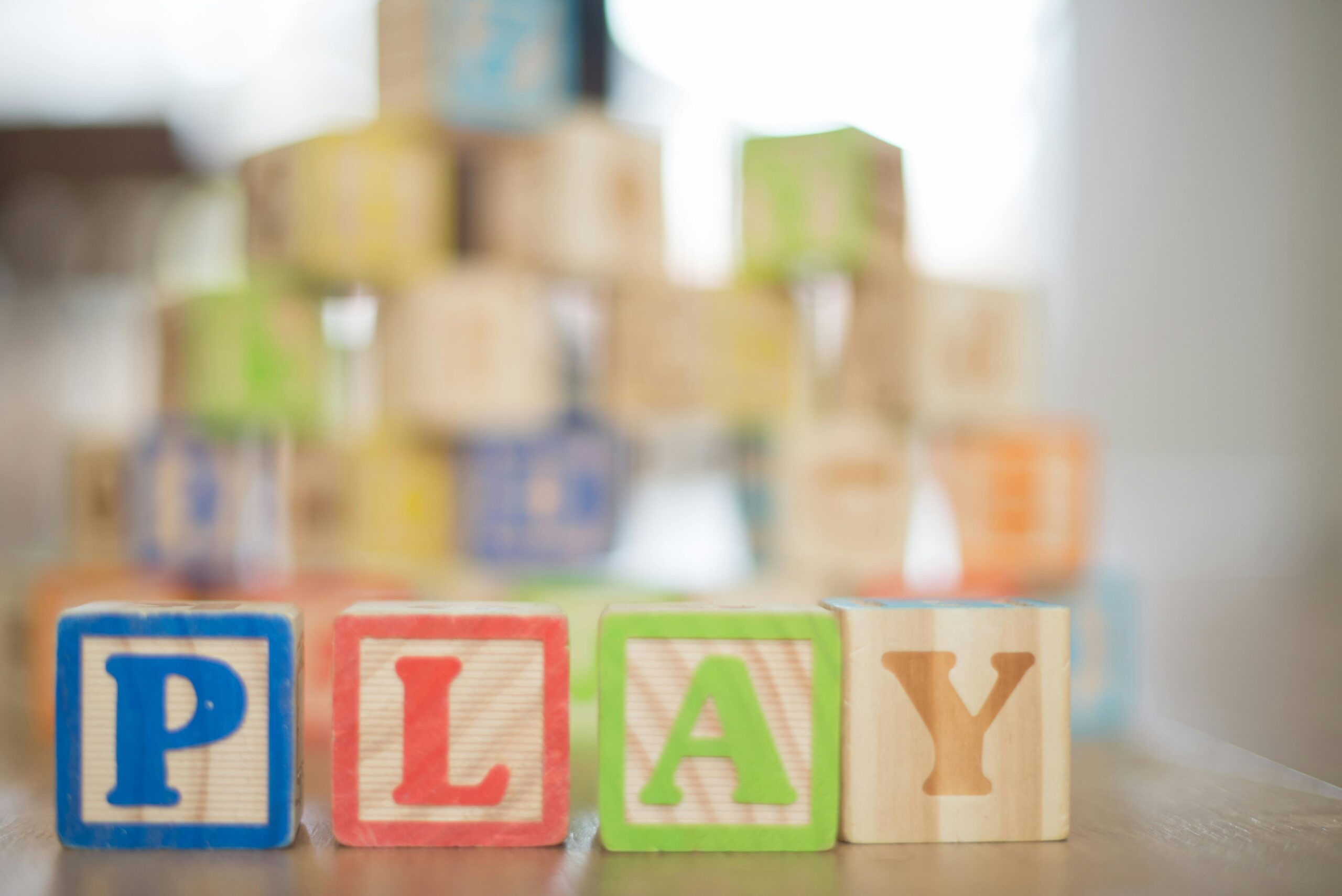 Wooden blocks forming the word PLAY in colorful letters.